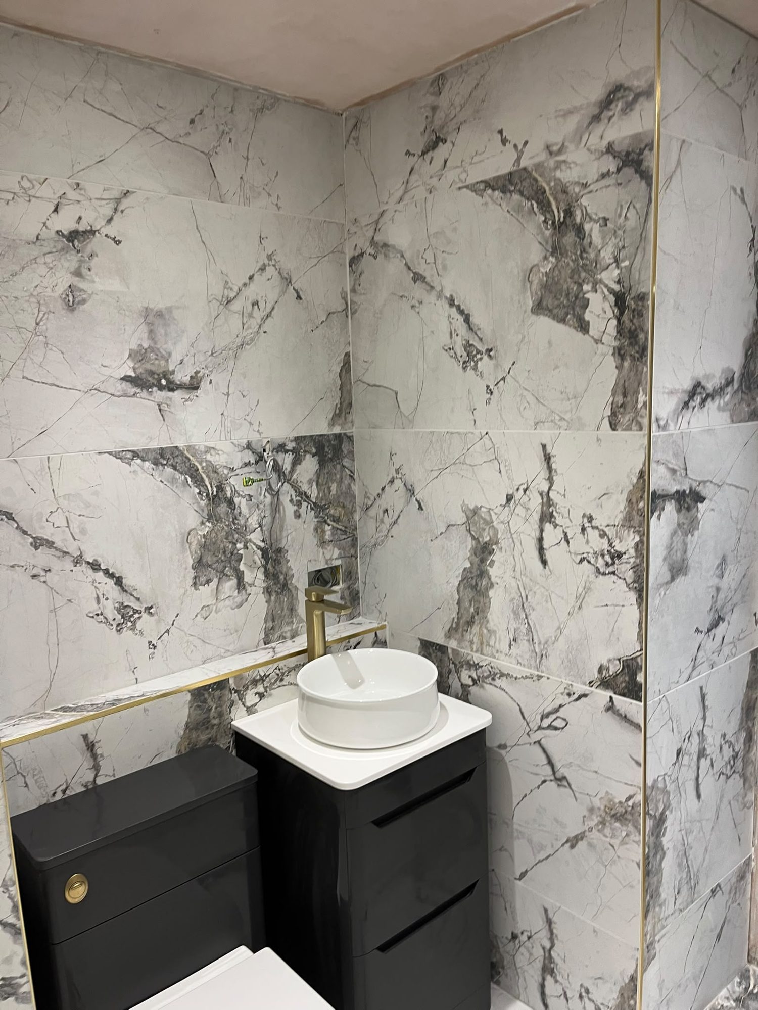 Bathroom vanity basin with marble-effect wall finish