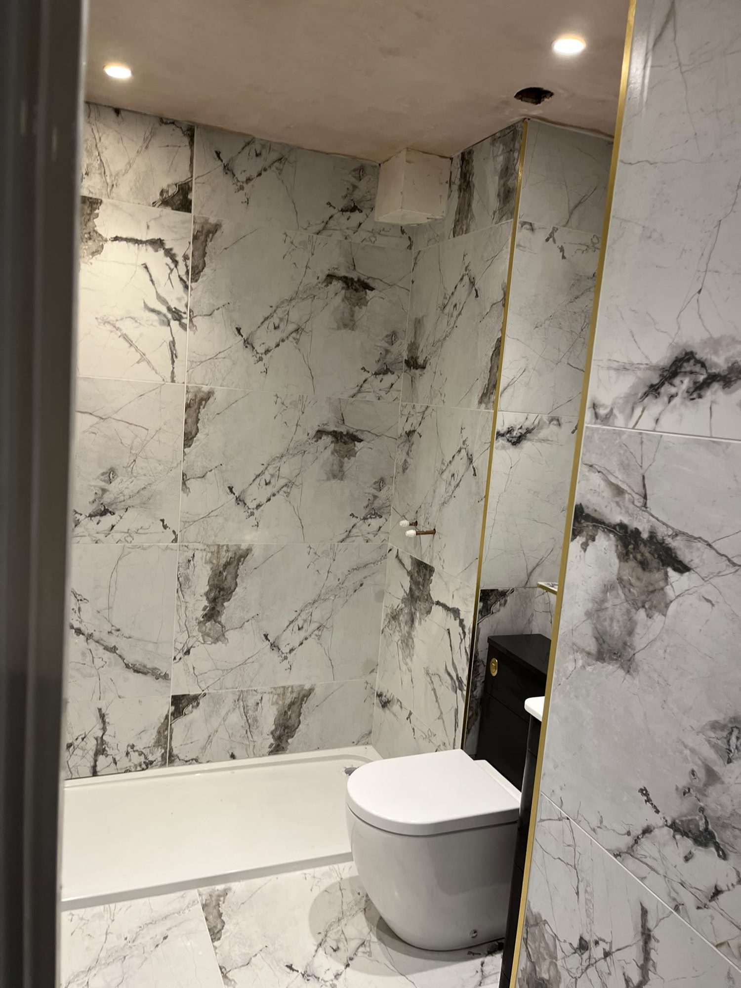 Marble-effect bathroom with glazed shower, toilet and vanity basin