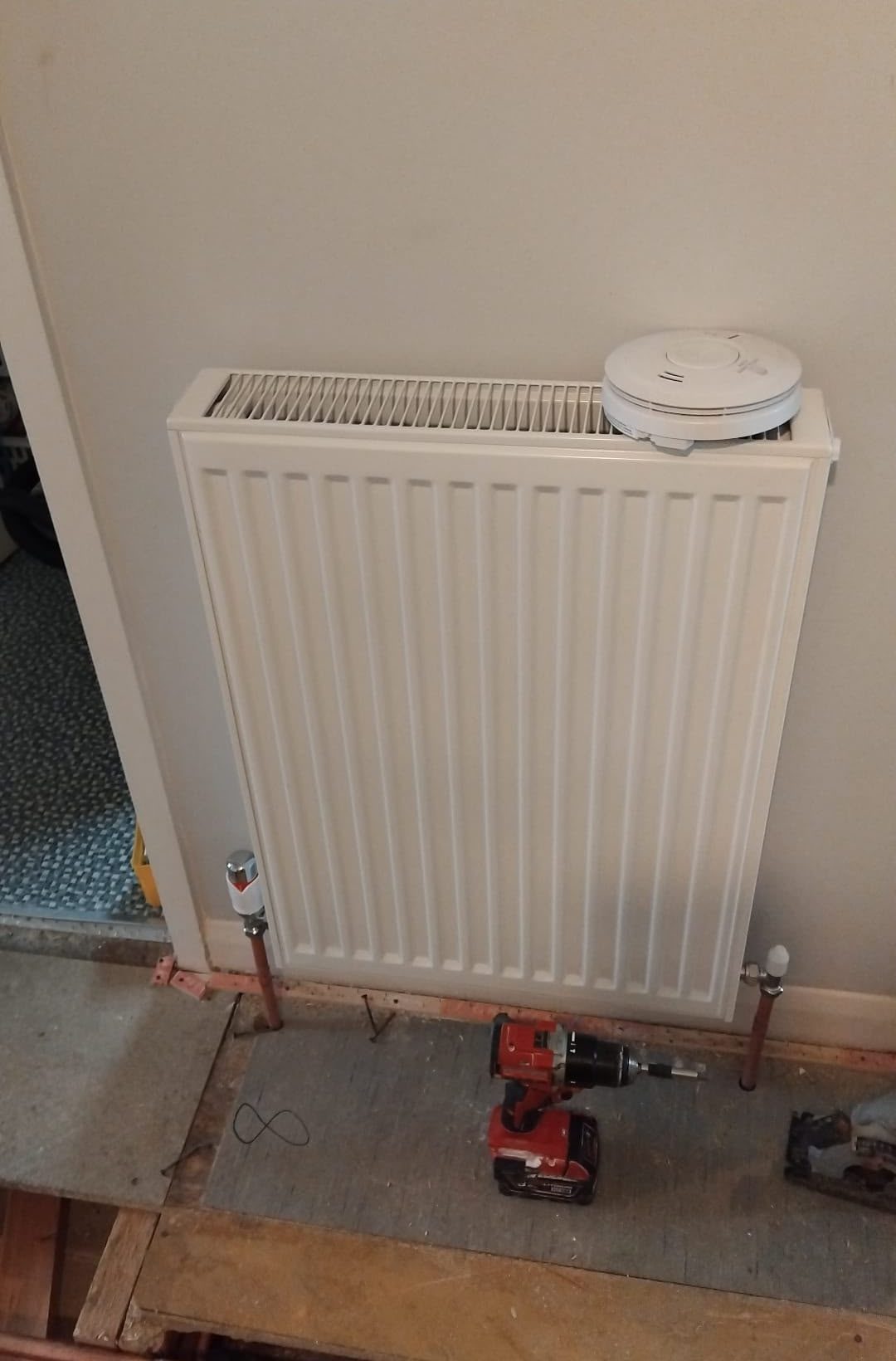 White domestic radiator with connected pipework