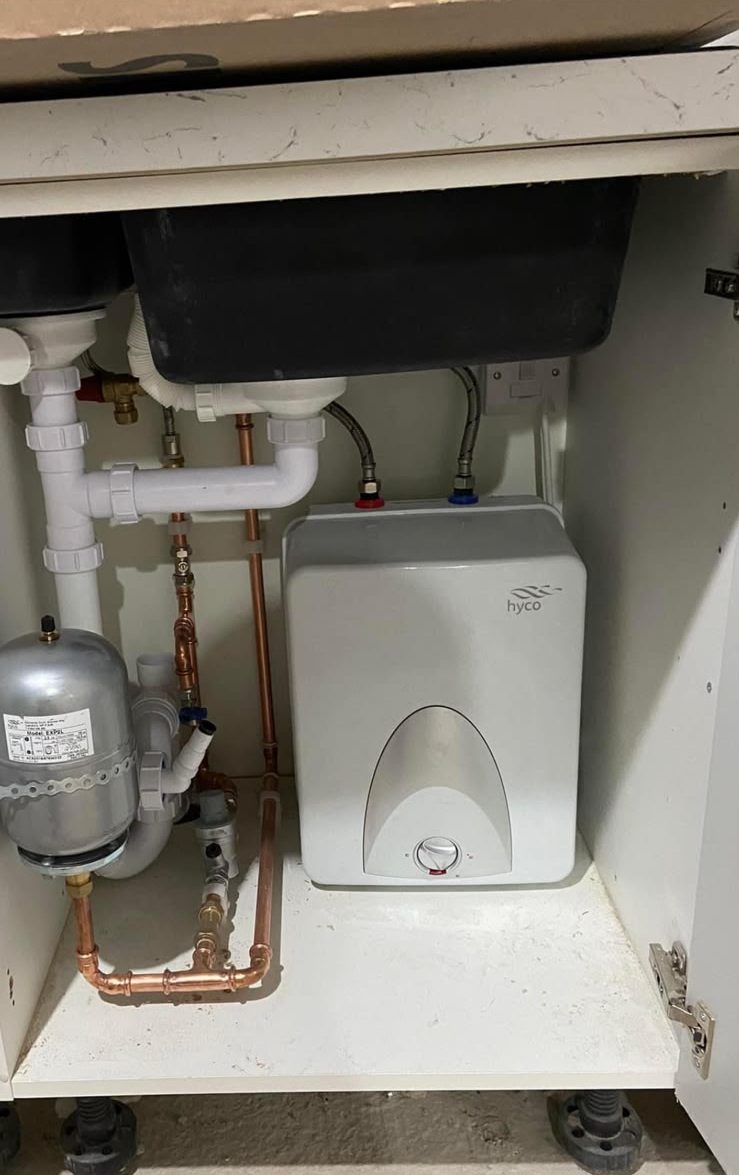 Under-sink water heater with copper supply pipes and sink waste plumbing
